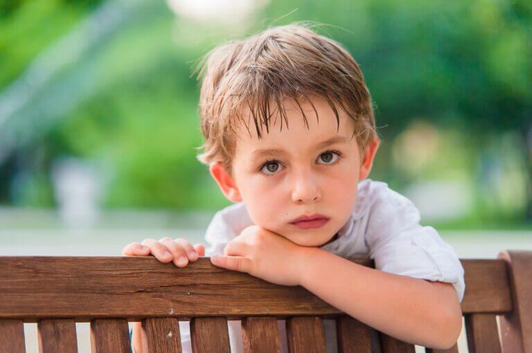 Enfant accoudé à un banc.