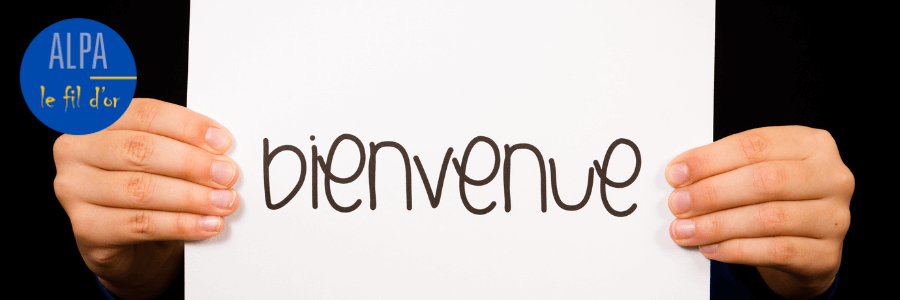 Panneau avec le mot - Bienvenue - tenu par deux mains.